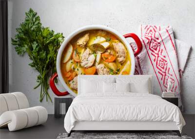 Chicken stew with potatoes and carrots in red saucepan. Chicken soup with vegetables and herbs. Comfort food recipe. Wall mural