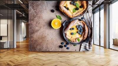 Dutch baby pancakes with berries and lemon in cast iron frying pan, top view. Wall mural