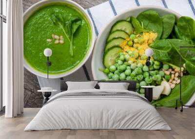 Green peas spinach basil pesto and Ingredients in a white bowl on a wooden background. Love for a healthy raw food concept. Wall mural