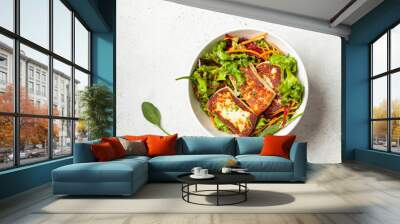 Green salad with grilled halloumi cheese, beet and carrot in a white bowl, top view. Cypriot or Greek food concept. Wall mural