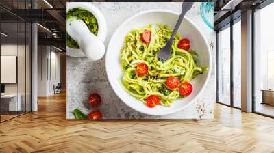 Zucchini pasta with pesto, avocado and tomatoes in white plate, top view. Raw vegan food concept. Wall mural