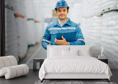 Smart engineer man worker wearing safety helmet doing stocktaking of product management in cardboard box on shelves in warehouse. Factory physical inventory count. Wall mural