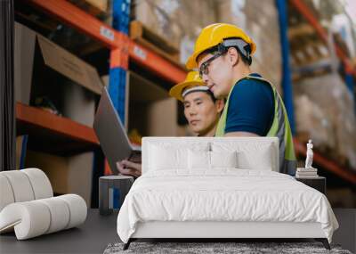 Two warehouse workers using a digital tablet while recording inventory. Logistics employees working with warehouse management software in a large distribution centre. Wall mural