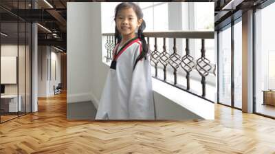 thai asian girl kid standing relax beside windows after train taekwando in suit smile funny happy cute Wall mural