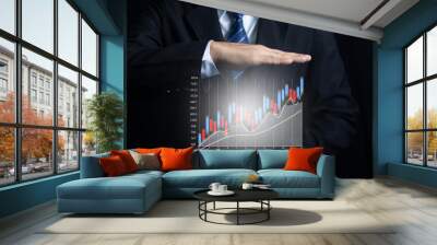 Businessman holding tablet showing company growth graph Wall mural