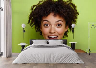 Joyful Woman with Curly Hair Against Green Background Wall mural