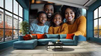 A family of four, two adults and two children, are sitting on a couch and smiling. Scene is happy and warm, as the family appears to be enjoying each other's company Wall mural