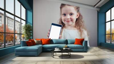 little girl holding a smartphone with a white screen Wall mural