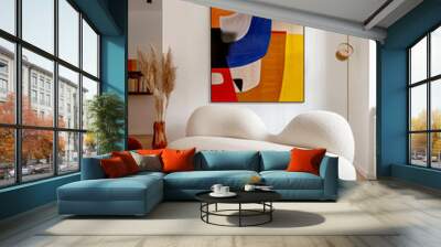 Boucle curved sofa on colorful rug near white wall with vibrant multicolored frame. Scandinavian interior design of modern living room. Wall mural