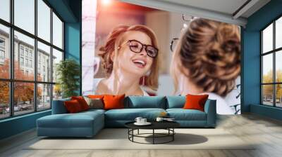 Beautiful girl wearing glasses in optician shop. Eyesight correction. Optics. Emotions. Ophthalmology. Wall mural