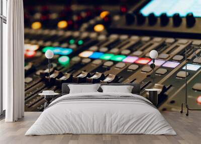 Control panel with colorful lights during a live sound mixing session. A detailed view of a sound mixing console with colorful buttons and faders during a live performance. Wall mural