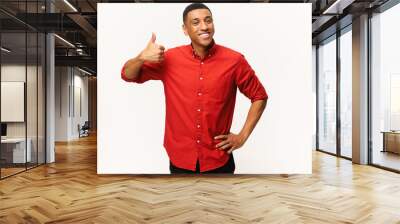 Cheerful African-American guy in red shirt showing thumb up isolated on white. Smiling multiracial man showing approval gesture at the camera, likes it Wall mural