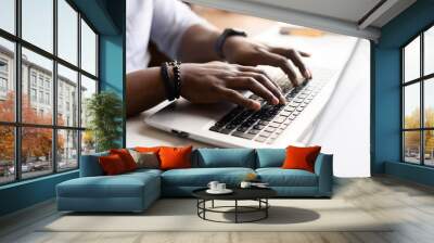 Close up image of male hands with accessories typing text on the laptop keyboard, working, responding to client e-mail, buying ordering items online. Electronics and modern wireless technology concept Wall mural