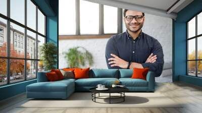 Headshot of skilled hindu male employee standing with arms crossed in modern office, successful confident mixed-race man wearing eyeglasses and smart casual, business portrait of indian entrepreneur Wall mural