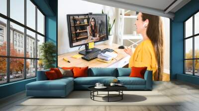 Video call, virtual meeting. Two young female co-workers is talking online via video connection Wall mural