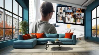 view from back above male shoulder on the laptop with diverse employees, coworkers on the screen, vi Wall mural