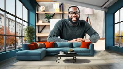 Webcam shot of African-American young guy in glasses, he looks into camera and smiles. Video screen, video chat, online call Wall mural