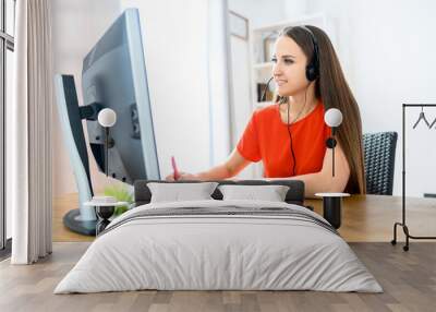 Woman using headset and pc for work Wall mural