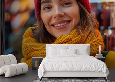 Portrait of young woman in red hat and scarf holding credit card at the Christmas market Wall mural