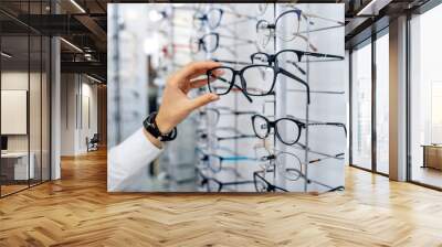 row of glasses at an opticians. eyeglasses shop. stand with glasses in the store of optics. woman ch Wall mural