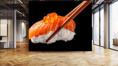 Salmon sushi nigiri in chopsticks isolated on black background.Close up. Wall mural