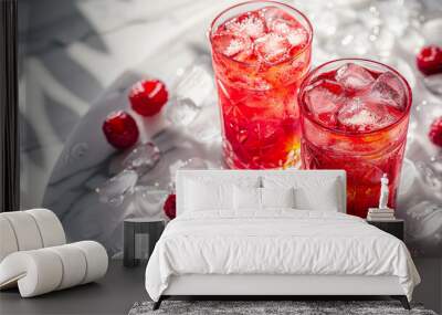 Two glasses of cold refreshing drink with ice and raspberries on white marble table Wall mural