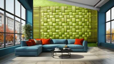 Woven bamboo mat, flat lay, toned image, light green background Wall mural