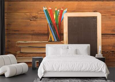 small wooden blank blackboard with colorful pencils and stack bo Wall mural