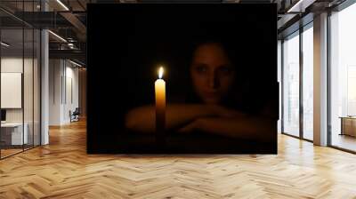 Girl with candle fire in the dark at night. Wall mural