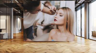 Makeup Artist with Brush in Hand and Blond Model. Wall mural