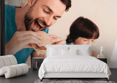 Smiling Son and Father Have Lunch in Kitchen. Wall mural