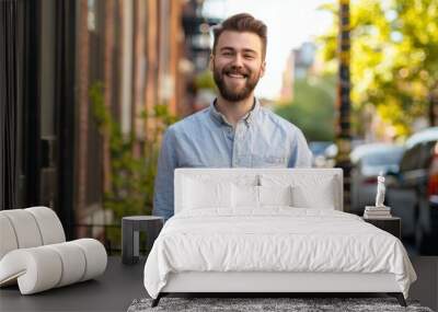 A man with a beard is smiling and standing in front of a building Wall mural