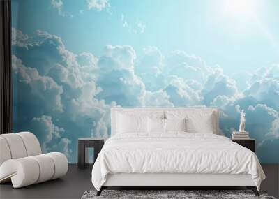 The image shows a bright blue sky filled with fluffy white clouds. The sun is shining brightly, casting a soft glow on the clouds. The clouds are clustered together, creating a beautiful and peaceful  Wall mural