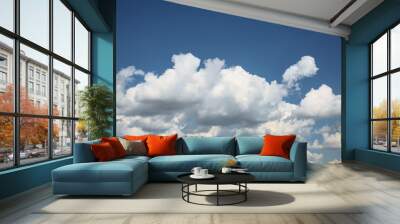 Beautiful fluffy clouds in the blue sky. City landscape. Good weather. Wall mural