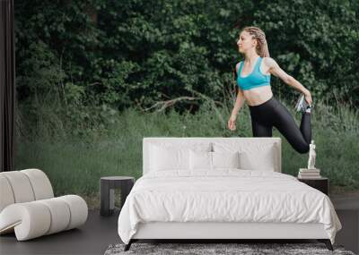 Beautiful sporty woman stretching body in nature Wall mural