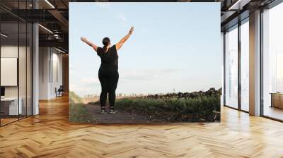 Body positive, freedom, high self esteem, confidence, happiness, inspiration, success, positive affirmation. Overweight woman celebrating rising hands to the sky Wall mural