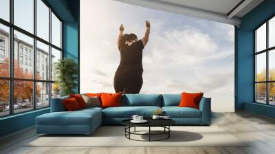 Body positive, success, freedom, happiness, confidence, self esteem. Overweight woman rising hands to the sky. Obesity and outdoor activity Wall mural