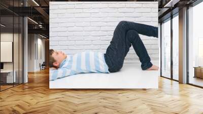 Cute boy lying on the floor of his room resting. Copy space Wall mural