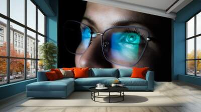 Girl works on internet. Reflection at the glasses from laptop..Close up of woman's eyes with black female glasses for working at a computer. Eye protection from blue light and rays. Wall mural