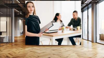 Join our team. Hiring and teamwork concept. Young successful woman standing with her co-workers at background. People, human resources and office culture Wall mural