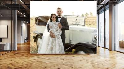 newlyweds in a retro cabriolet. rustic wedding. beautiful nature overlooking the sea. collector's wedding car Wall mural