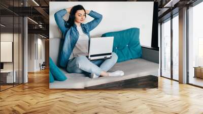 Remote work. Young woman learning from home online using laptop and headphones. Distance learning, isolation, freelance business. Wall mural