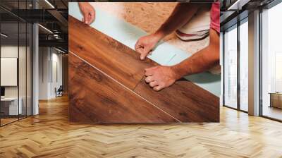 Workers are making laminate flooring in apartment. Maintenance repair works renovation in the flat. Restoration of wooden parquet floor planks indoors. Wall mural