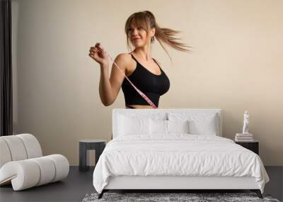 slim healthy girl in black underwear with measuring tape at waist. fit woman poses in high waist pan Wall mural