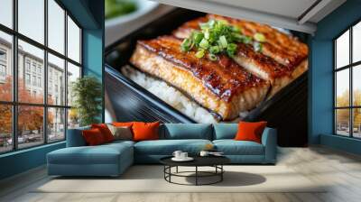 A close-up of grilled eel, tender and glazed, served atop fluffy rice in a glossy lacquered box. The rich, caramelized eel contrasts beautifully with the pristine rice, offering a mouthwatering view. Wall mural