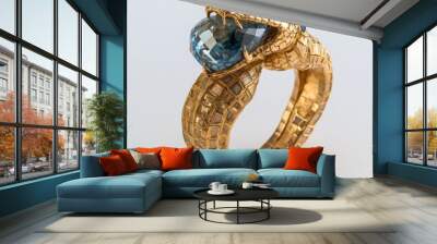 Close-up of a luxurious gold ring for men in the shape of a snake. Gold ring with a snake holding a blue gemstone in its mouth. Wall mural