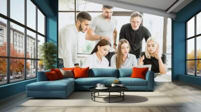 Team of young people in work process in front of laptop Wall mural