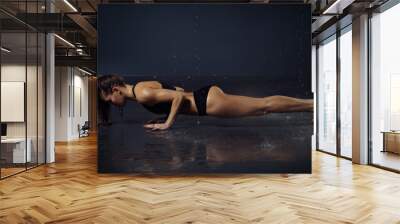 beautiful young girl in top and shorts doing yoga pose under the drops of water Wall mural