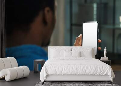 Close up of African American man holding new black smartphone with blank screen in hands. Mobile phone with blank copy space screen for your text Wall mural