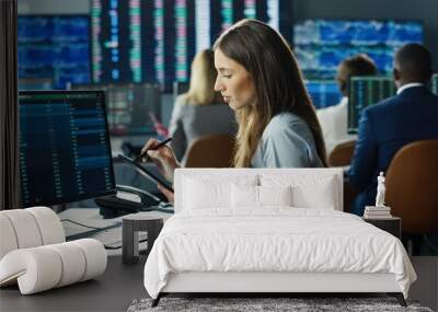 Female stock trader working at stock exchange office using digital tablet computer on background of multiple monitors showing data, ticker numbers and graphs. Wall mural